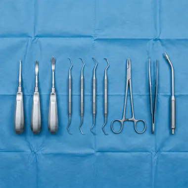 An oral surgery instrument tray laid out on a sterile drape